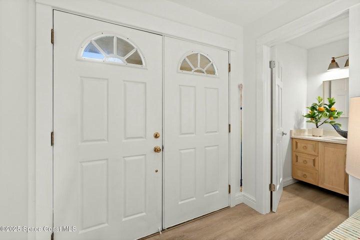 Entry with double glass-panel front doors and powder bath vanity, Riverwest condo, Cocoa Beach