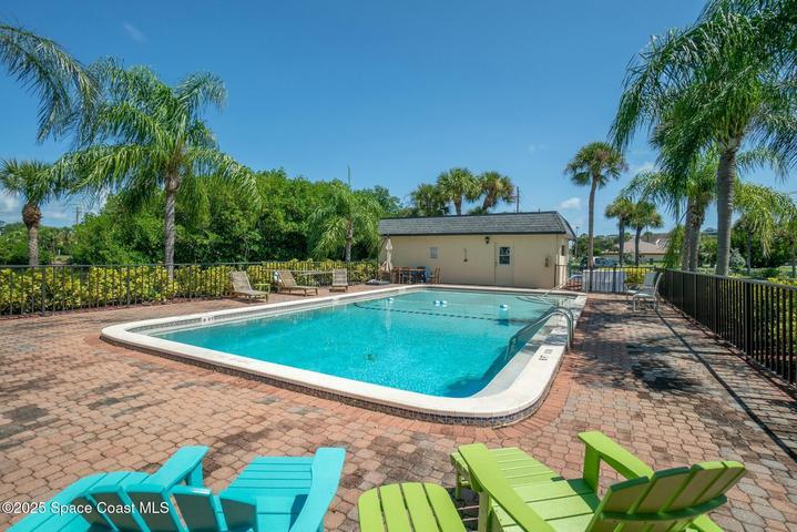 Riverwest community pool deck with colorful lounge chairs and palm trees, Cocoa Beach, Florida
