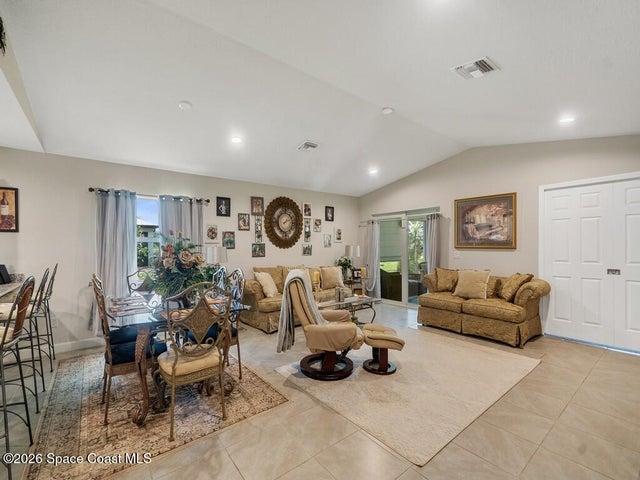 Vaulted ceiling great room featuring recessed lighting, ceramic tile flooring, and sliding glass doors to the exterior