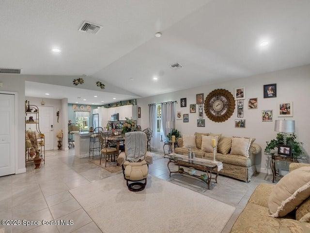 Open-concept living area featuring a vaulted ceiling with recessed lighting
