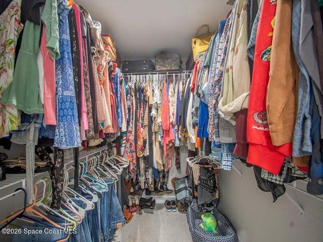 Walk-in closet featuring built-in wire shelving and hanging rods