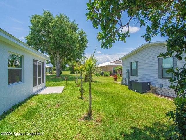 Expansive green lawn with mature trees and established landscaping