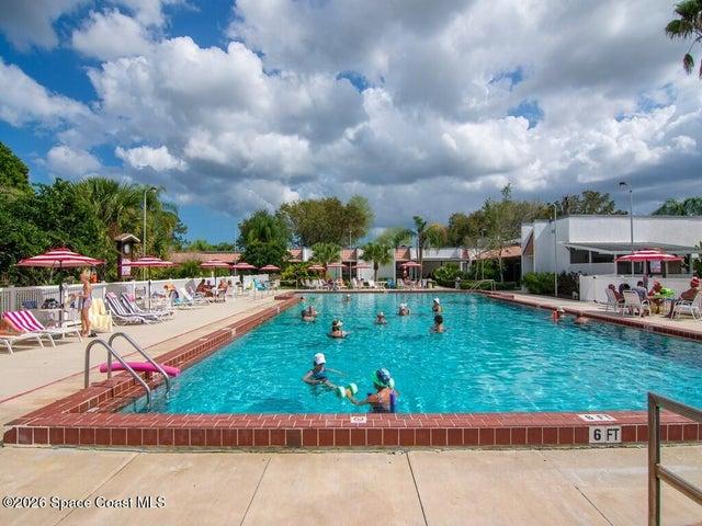 Rectangular swimming pool featuring a brick coping, concrete deck, and perimeter fencing