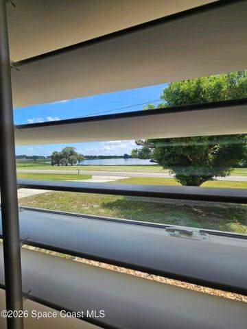 view of lake from the living room. Plantation shutters throughout home