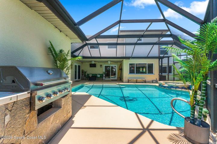 Pool from screen door to back yard, notice the out door kitchen!