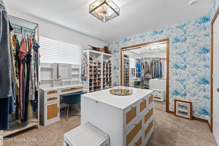 4th bedroom, currently being used as a large primary closet dressing room, has access both from the hall and from the primary bath
