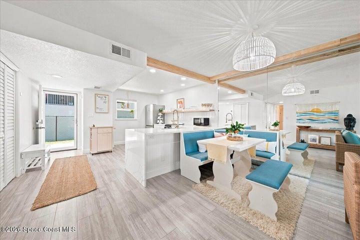 The open-concept dining area features a custom breakfast nook topped with the same beautiful quartz as the kitchen's waterfall countertops, creating a seamless, designer-inspired flow throughout the living space.