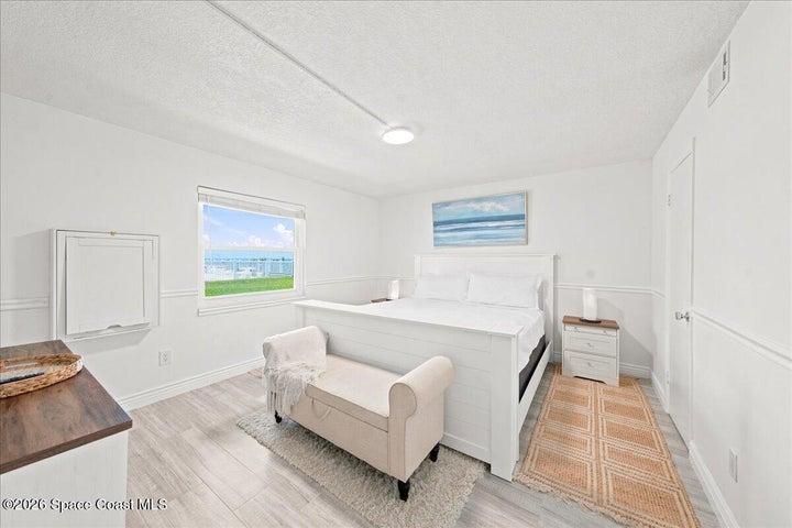 Bright and spacious primary bedroom featuring abundant natural light, generous closet space, and a peaceful coastal ambiance