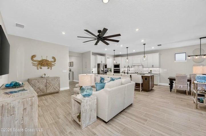 OPEN CONCEPT - Flood of recessed lights, designer lighting fixtures, 2 sets of impact sliders for near wall to wall view of extended patio, landscaped backyard and natural preserve.