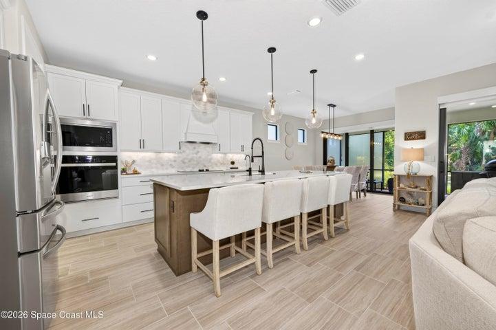 Gourmet Kitchen: Level 5 Calcutta Gold quartz countertops, Level 5 marble fish scale fan-shape backsplash, Level 4 white wood cabinetry, Contrasting Level 4 wood-tone island cabinetry creating a custom two-tone desinger kitchen, Microwave/Wall oven, LG 4 DOOR REFRIGERATOR featuring: InstaView Door-in-Door, Craft ice maker, Convertible fridge/freezer drawer and CUSTOM BUTLER PANTRY