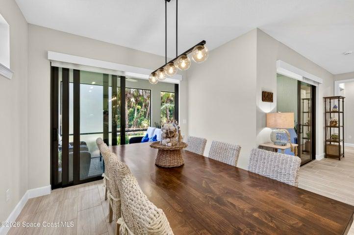 DINING AREA -Triple sliders added in lieu of window to enhance indoor/outdoor living and tropical preserve views. Two transom windows. Designer Chandelier.