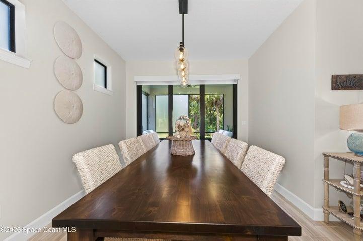 DINING AREA -Triple sliders added in lieu of window to enhance indoor/outdoor living and tropical preserve views. Two transom windows. Designer Chandelier.