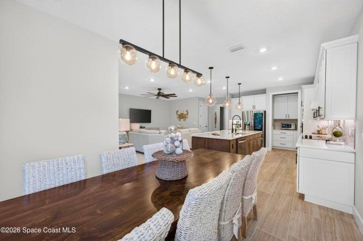 DINING AREA -Triple sliders added in lieu of window to enhance indoor/outdoor living and tropical preserve views. Two transom windows. Designer Chandelier.