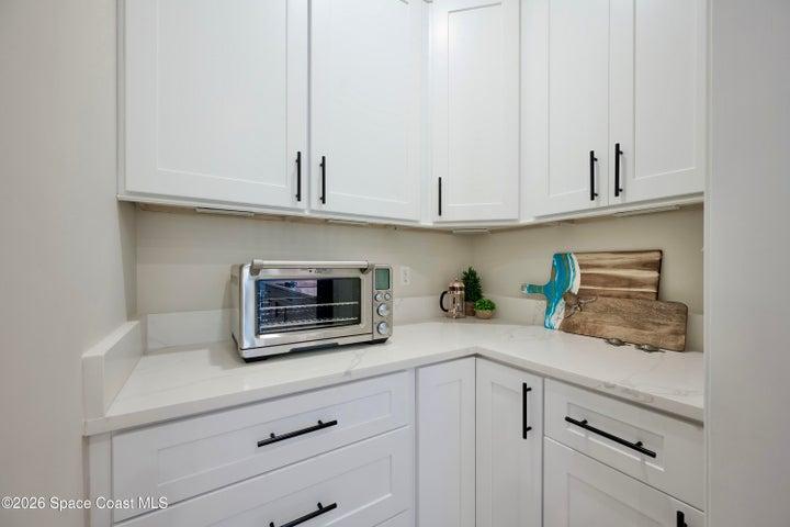BUTLERS PANTRY and Appliance Center.  A functional and aesthetic fluid extenstion of the kitchen: Quartz countertop, Ideal prep-station and/or coffee bar, Motion-sensor lighting, Custom cabinetry with pot drawers, soft close, two Lazy Susans, 42" Upper cabs++.