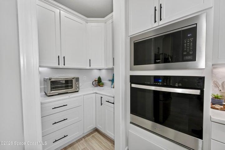 Gourmet Kitchen: Level 5 Calcutta Gold quartz countertops, Level 5 marble fish scale fan-shape backsplash, Level 4 white wood cabinetry, Contrasting Level 4 wood-tone island cabinetry creating a custom two-tone desinger kitchen, Microwave/Wall oven, LG 4 DOOR REFRIGERATOR featuring: InstaView Door-in-Door, Craft ice maker, Convertible fridge/freezer drawer and CUSTOM BUTLER PANTRY