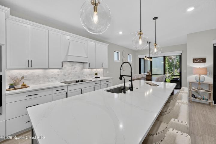 Gourmet Kitchen: Level 5 Calcutta Gold quartz countertops, Level 5 marble fish scale fan-shape backsplash, Level 4 white wood cabinetry, Contrasting Level 4 wood-tone island cabinetry creating a custom two-tone desinger kitchen, Microwave/Wall oven, LG 4 DOOR REFRIGERATOR featuring: InstaView Door-in-Door, Craft ice maker, Convertible fridge/freezer drawer and CUSTOM BUTLER PANTRY