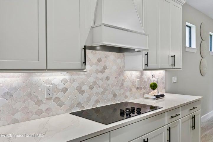 Gourmet Kitchen: Level 5 Calcutta Gold quartz countertops, Level 5 marble fish scale fan-shape backsplash, Level 4 white wood cabinetry, Contrasting Level 4 wood-tone island cabinetry creating a custom two-tone desinger kitchen, Microwave/Wall oven, LG 4 DOOR REFRIGERATOR featuring: InstaView Door-in-Door, Craft ice maker, Convertible fridge/freezer drawer and CUSTOM BUTLER PANTRY