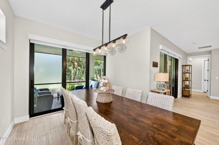 DINING AREA -Triple sliders added in lieu of window to enhance indoor/outdoor living and tropical preserve views. Two transom windows. Designer Chandelier.