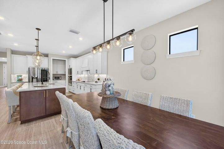 DINING AREA -Triple sliders added in lieu of window to enhance indoor/outdoor living and tropical preserve views. Two transom windows. Designer Chandelier.