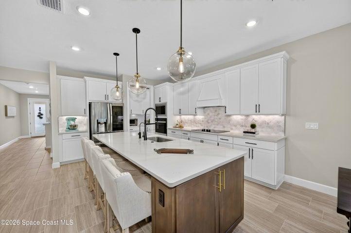 Gourmet Kitchen: Level 5 Calcutta Gold quartz countertops, Level 5 marble fish scale fan-shape backsplash, Level 4 white wood cabinetry, Contrasting Level 4 wood-tone island cabinetry creating a custom two-tone desinger kitchen, Microwave/Wall oven, LG 4 DOOR REFRIGERATOR featuring: InstaView Door-in-Door, Craft ice maker, Convertible fridge/freezer drawer and CUSTOM BUTLER PANTRY
