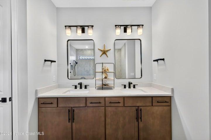ENSUITE BATHROOM: Level 4 cabinetry with soft close wood doors and drawers, Level 3 quartz vanity countertop, Comfort-Height Kohler toilet, Upgraded sink faucets and shower fixtures, Large Roman shower featuring: transom window for natural light and privacy, floor-to-ceiling Level 5 vertical porcelain tile, Designer vanity lighting, Upgraded double-sink vanity.