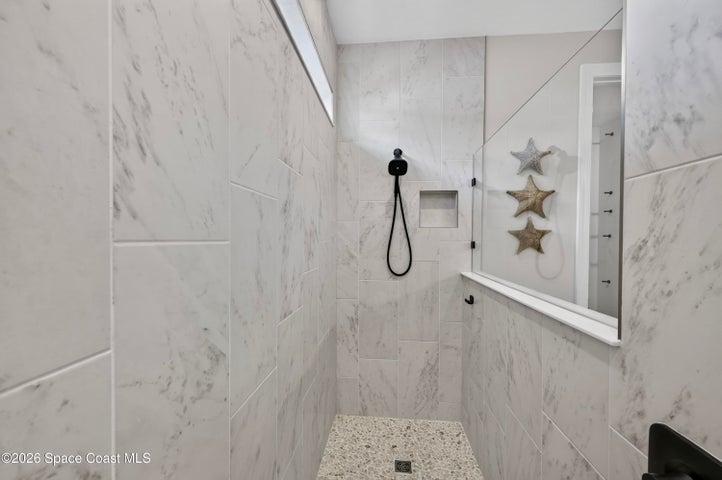 ENSUITE BATHROOM: Level 4 cabinetry with soft close wood doors and drawers, Level 3 quartz vanity countertop, Comfort-Height Kohler toilet, Upgraded sink faucets and shower fixtures, Large Roman shower featuring: transom window for natural light and privacy, floor-to-ceiling Level 5 vertical porcelain tile, Designer vanity lighting, Upgraded double-sink vanity.