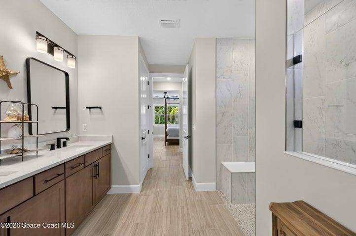 ENSUITE BATHROOM: Level 4 cabinetry with soft close wood doors and drawers, Level 3 quartz vanity countertop, Comfort-Height Kohler toilet, Upgraded sink faucets and shower fixtures, Large Roman shower featuring: transom window for natural light and privacy, floor-to-ceiling Level 5 vertical porcelain tile, Designer vanity lighting, Upgraded double-sink vanity.