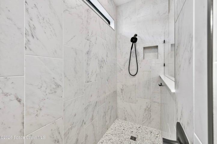 ENSUITE BATHROOM: Level 4 cabinetry with soft close wood doors and drawers, Level 3 quartz vanity countertop, Comfort-Height Kohler toilet, Upgraded sink faucets and shower fixtures, Large Roman shower featuring: transom window for natural light and privacy, floor-to-ceiling Level 5 vertical porcelain tile, Designer vanity lighting, Upgraded double-sink vanity.