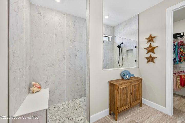 ENSUITE BATHROOM: Level 4 cabinetry with soft close wood doors and drawers, Level 3 quartz vanity countertop, Comfort-Height Kohler toilet, Upgraded sink faucets and shower fixtures, Large Roman shower featuring: transom window for natural light and privacy, floor-to-ceiling Level 5 vertical porcelain tile, Designer vanity lighting, Upgraded double-sink vanity.