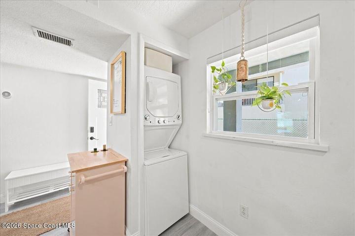 Convenient in-unit laundry area featuring a brand-new stacked washer and dryer, adding modern functionality and everyday ease