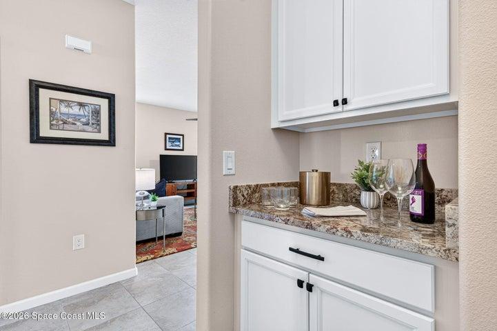 Elegant bar station tucked besides garage entry, offering charm or additional storage