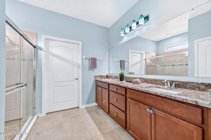 Double vanity accented by custom hand blown glass fixtures.