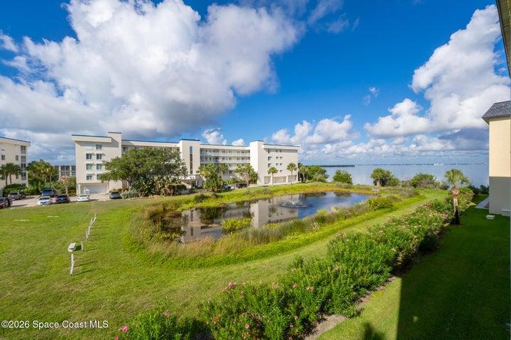 Balcony view, 3rd floor Unit 305 Riverwest condominiums in Cocoa Beach, Florida with wetland pond, fountain, and lush landscaping