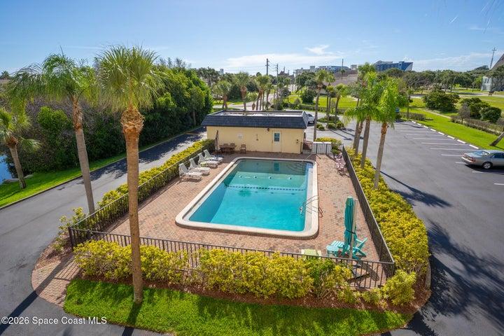 Riverwest community pool with brick paver deck and palm trees — Cocoa Beach, Florida condo association