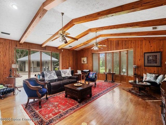 Vaulted ceiling featuring exposed wood beams and wood-finish flooring