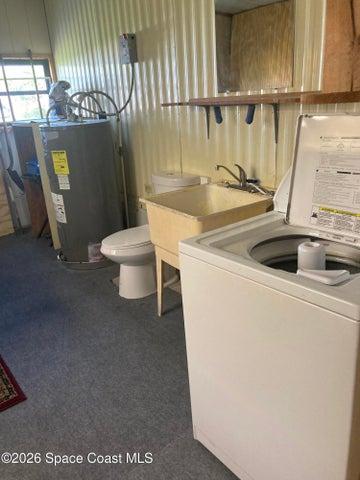 UTILITY ROOM WITH LAUNDRY SINK, WASHER AND DRYER PLUS A TOLIET