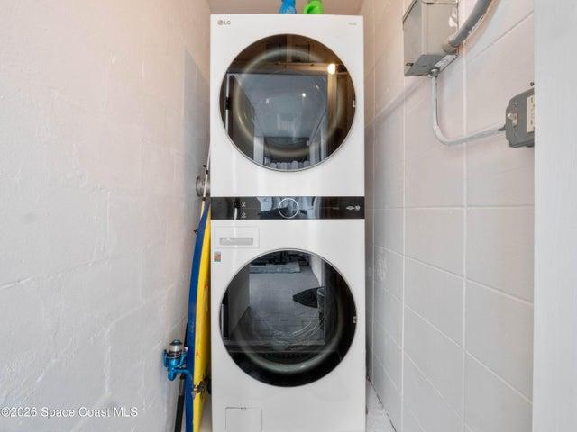 Convenient interior laundry area with stacked washer and dryer included.