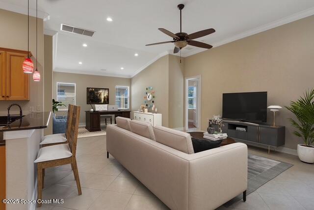 Living area with ornamental molding, recessed lighting, light tile patterned floors, and ceiling fan