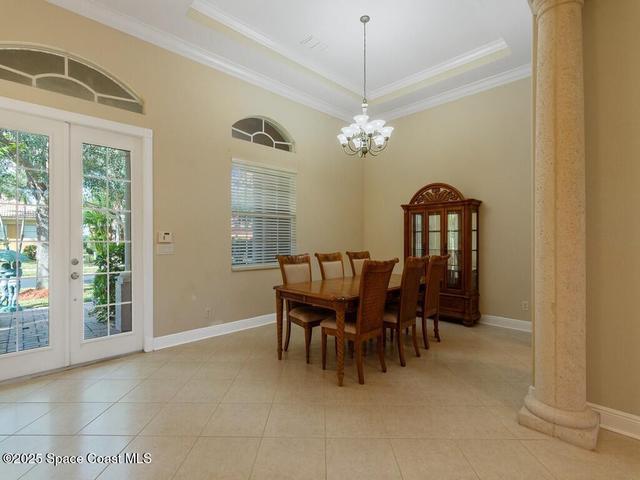 Dining room featuring arched walkways, decorative columns, ornamental molding, recessed lighting, and a chandelier