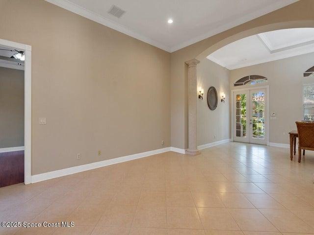 Unfurnished room with ornamental molding, light tile patterned floors, arched walkways, and recessed lighting