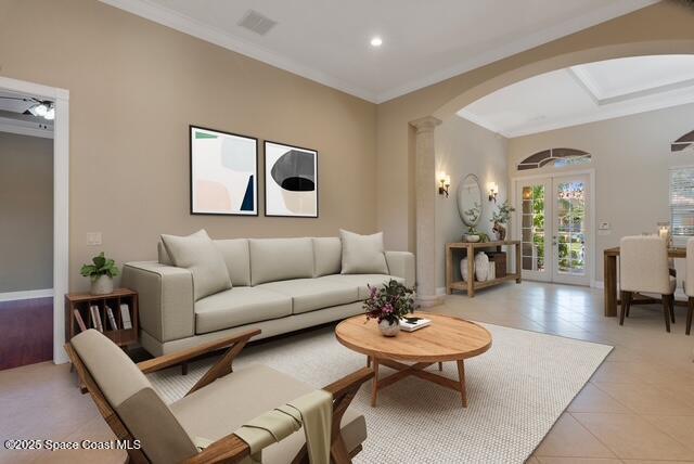 Living room featuring arched walkways, french doors, light tile patterned floors, and crown molding