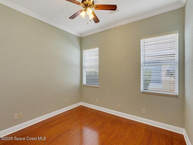 Unfurnished room featuring ornamental molding, wood finished floors, and a ceiling fan