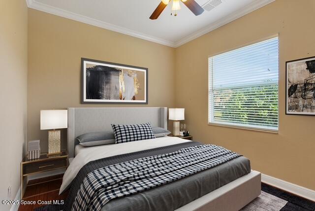 Bedroom featuring ornamental molding, a ceiling fan, and wood finished floors