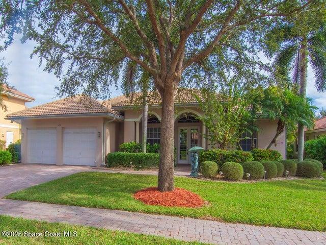 View of front of house featuring french doors, a front yard, stucco siding, and an attached garage