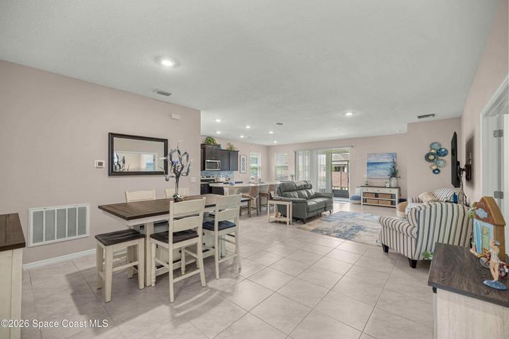 Open-concept interior featuring light tile flooring and neutral wall tones