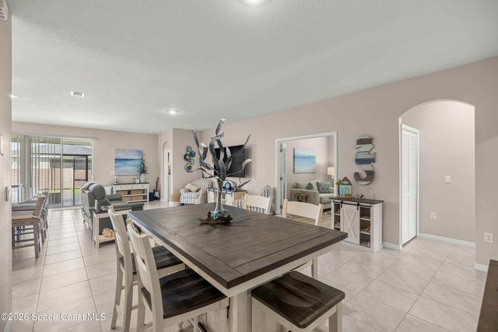 Expansive open-concept living area featuring light-toned tile flooring throughout