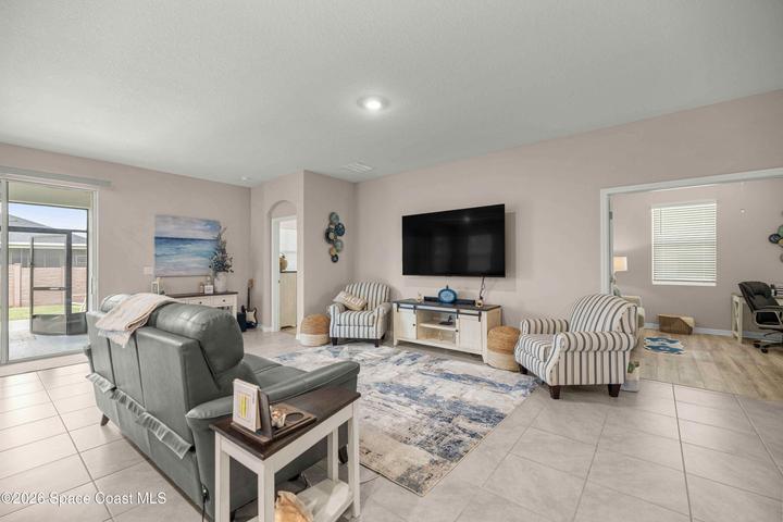 Spacious living area featuring large format floor tiles and light wall tones