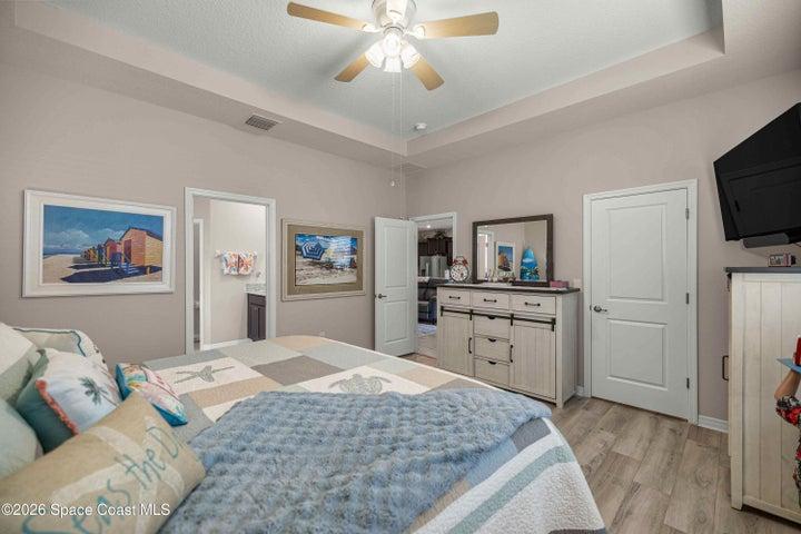 Bedroom featuring a tray ceiling with a ceiling fan