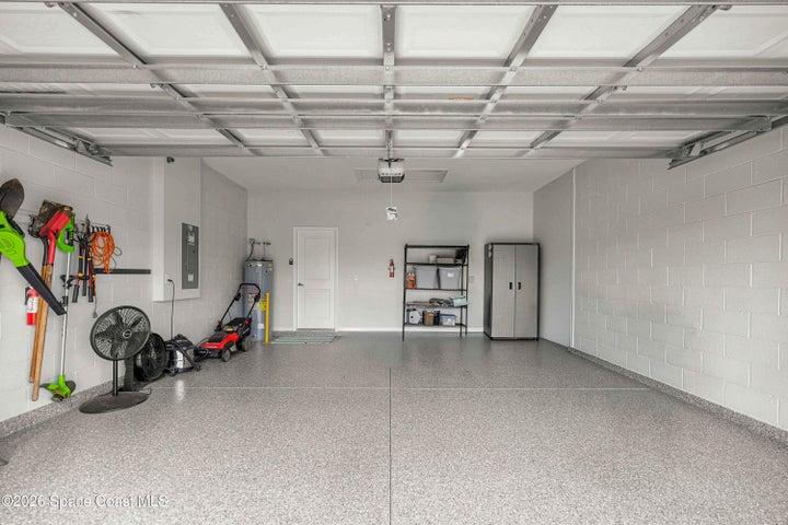 Spacious garage featuring a durable epoxy-coated floor, painted block walls, and an insulated garage door