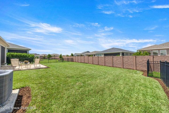Expansive green lawn with a concrete patio area